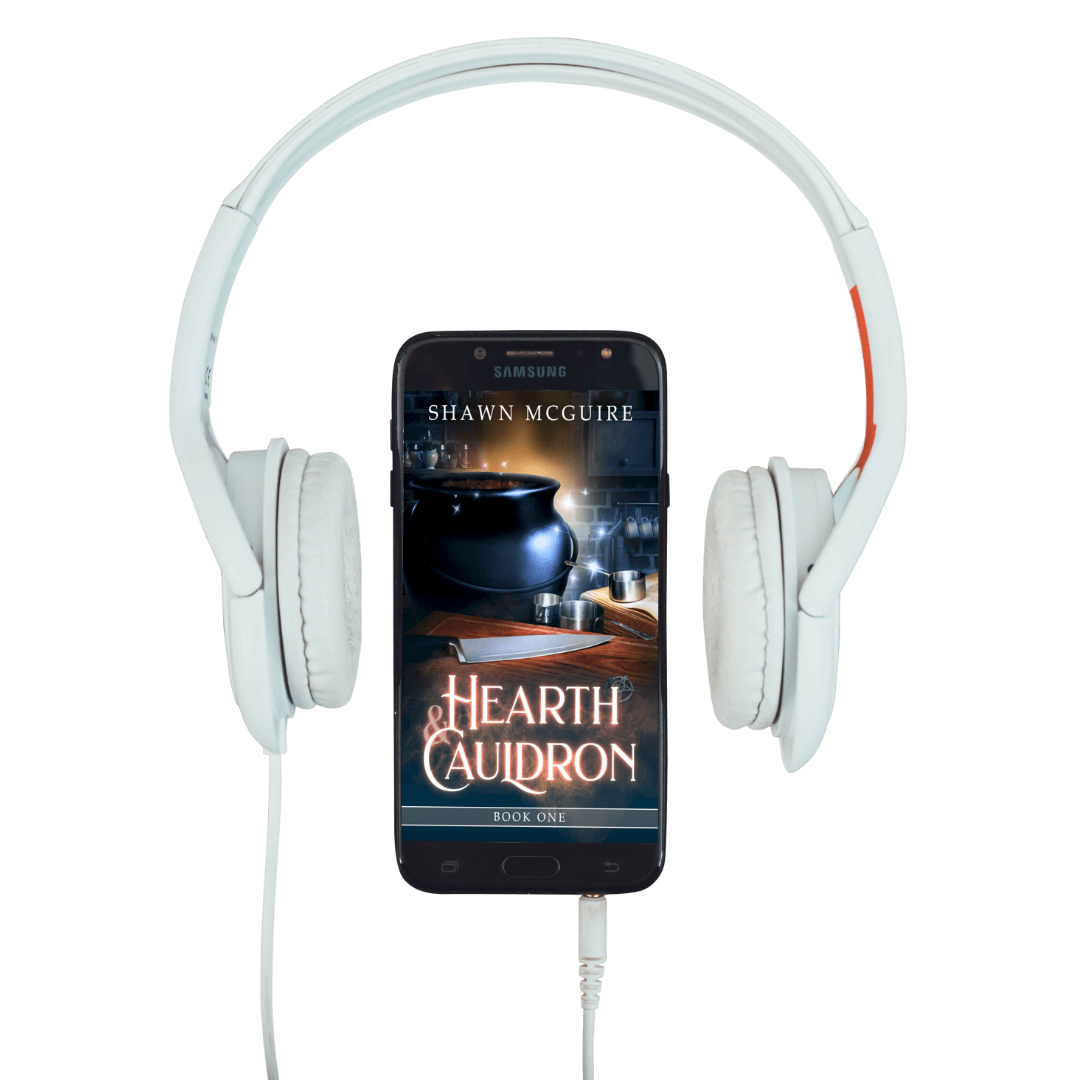 White headphones with a smartphone displaying 'Hearth & Caudron' by Shawn McGuire