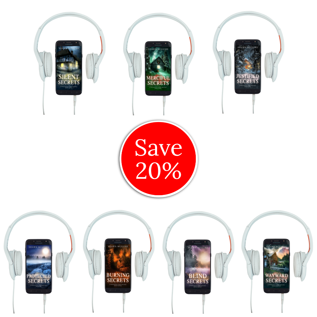 Audiobook covers on cellphones of Shawn McGuire’s Whispering Pines cozy murder mystery series collection books 7-13.