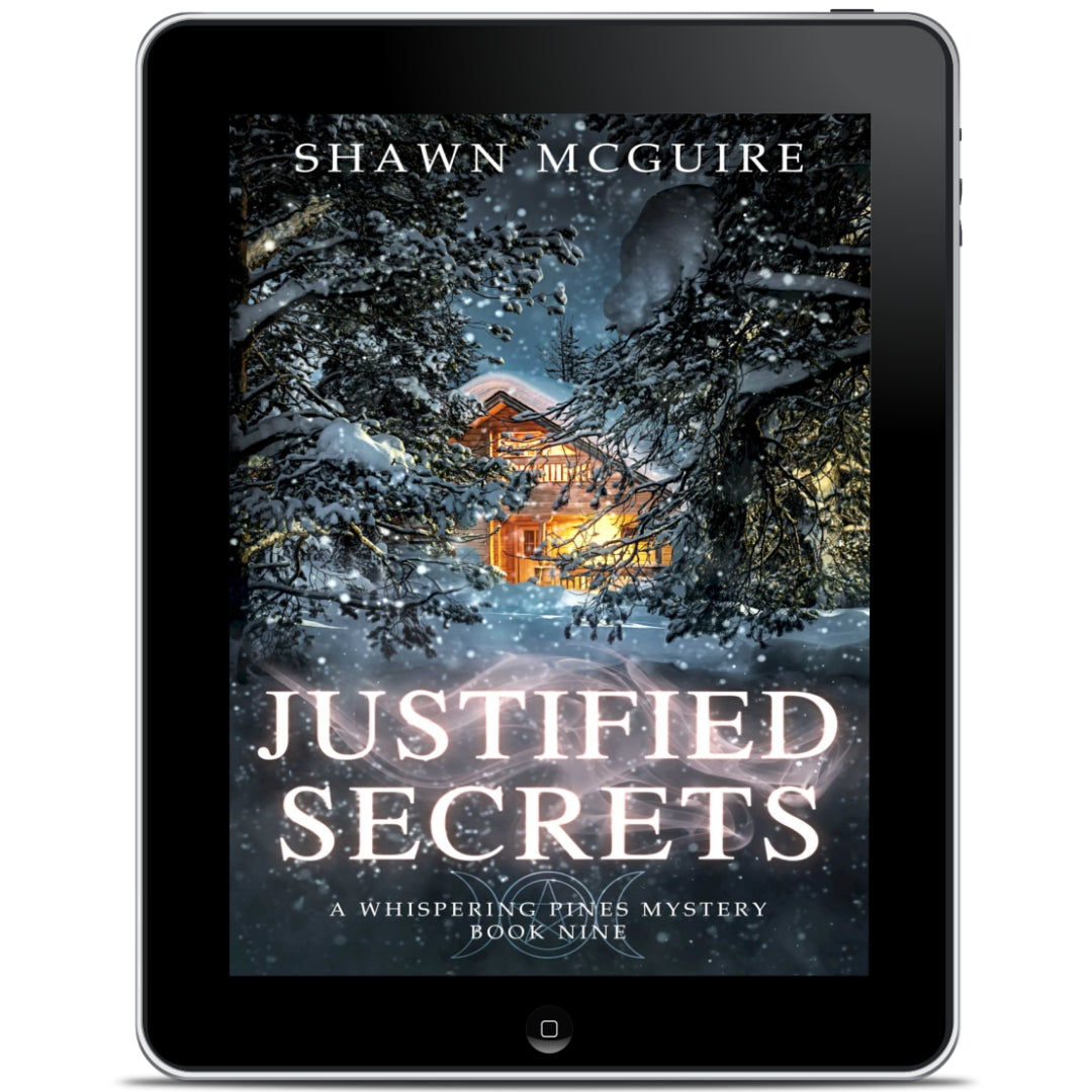 E-book cover on e-reader of Shawn McGuire's cozy murder mystery featuring a cabin in the woods during a snowstorm.