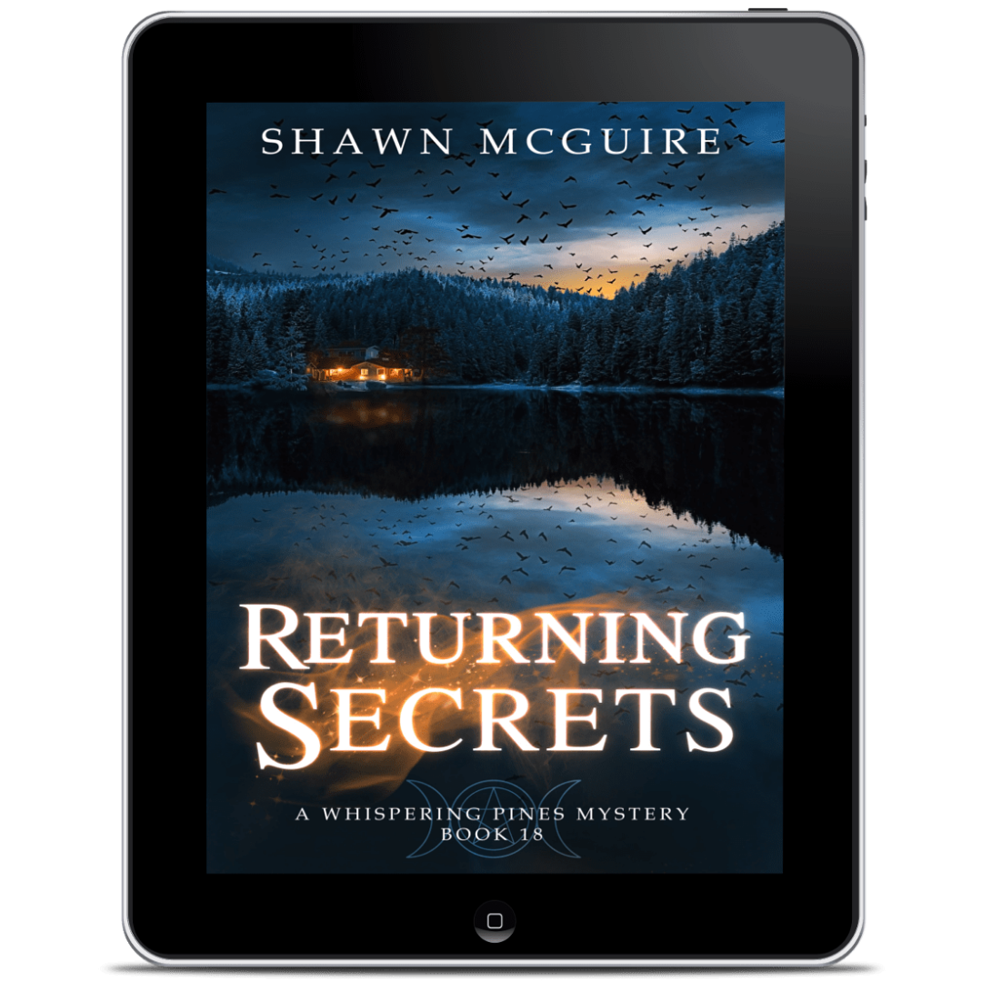 E-book cover on e-reader of Shawn McGuire’s cozy mystery with an image of a house on a lake surrounded by pine trees and a flock of crows in the sky.
