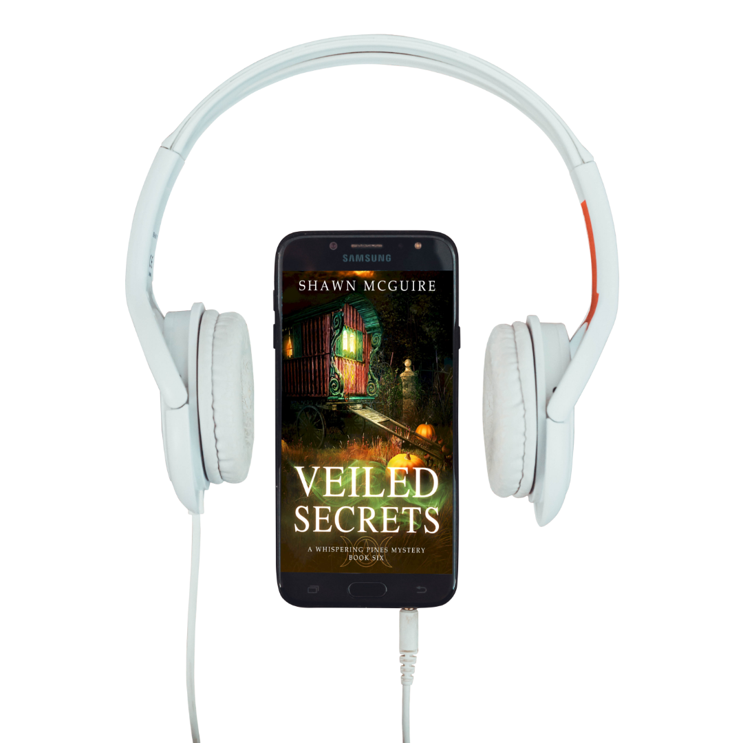 Audiobook cover on cellphone of Shawn McGuire's cozy murder mystery featuring a fortune teller’s wagon and Halloween pumpkins.
