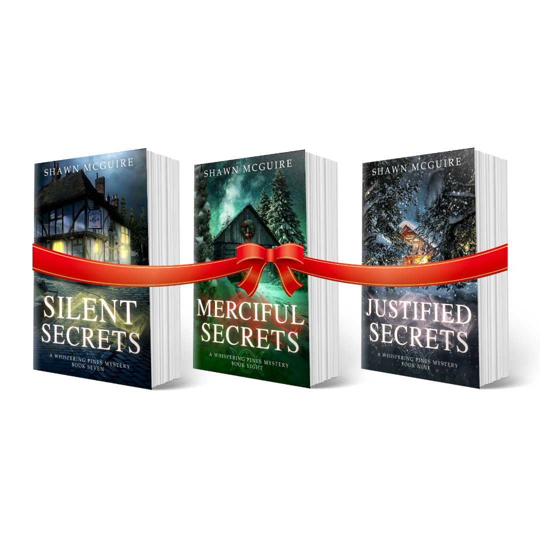 Paperback covers of Shawn McGuire’s 3-book cozy murder mystery series collection books 7-9 with a gift bow.