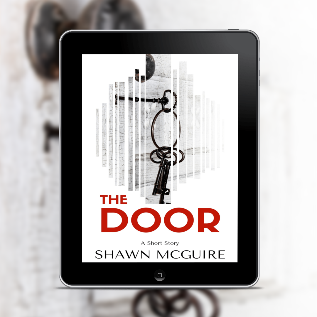 Tablet displaying the book cover of the short fantasy story 'The Door' by Shawn McGuire on a blurred background with keys.