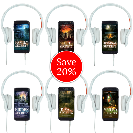 Audiobook covers on cellphones of Shawn McGuire’s Whispering Pines cozy murder mystery series collection books 1-6.
