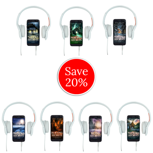Audiobook covers on cellphones of Shawn McGuire’s Whispering Pines cozy murder mystery series collection books 7-13.