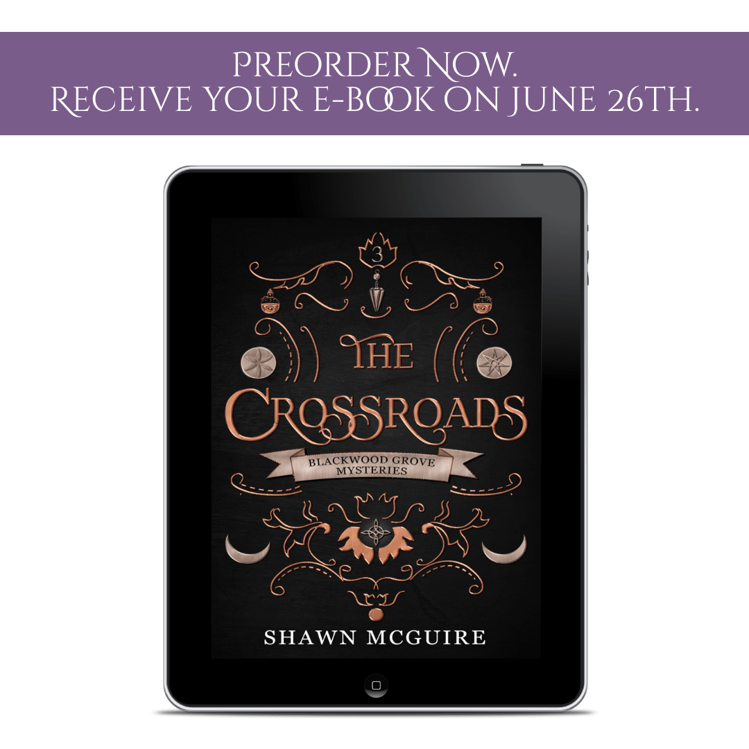 Tablet displaying the cover of 'The Crossroads' by Shawn McGuire with preorder notification text above.