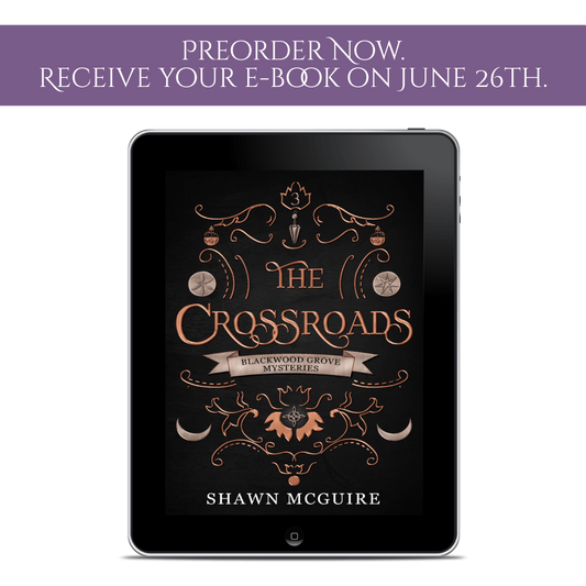 Tablet displaying the cover of 'The Crossroads' by Shawn McGuire with preorder notification text above.