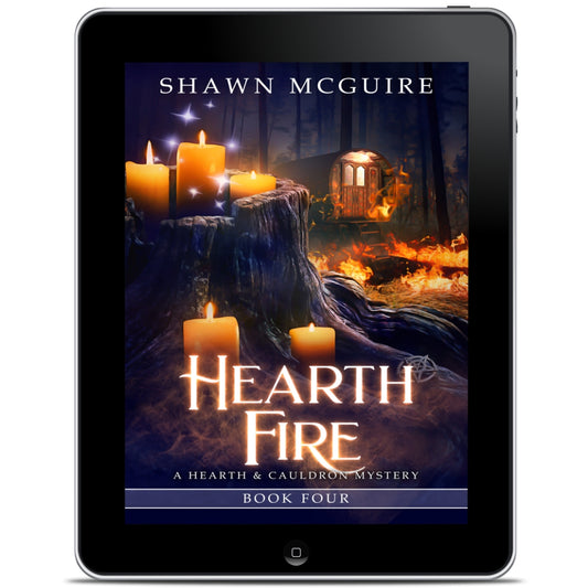 E-book cover on e-reader of Shawn McGuire’s witch cozy midlife mysteries with a burning fortune teller wagon in background and lit candles on tree stump in foreground. 