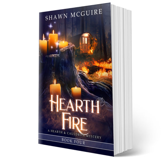 Cover of Shawn McGuire’s witch cozy midlife mysteries with a burning fortune teller wagon in background and lit candles on tree stump in foreground. 