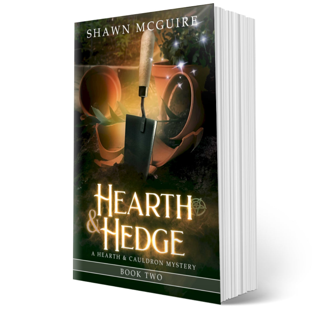 Cover of Shawn McGuire’s witch cozy midlife mysteries with broken plant pots and a hand trowel. 
