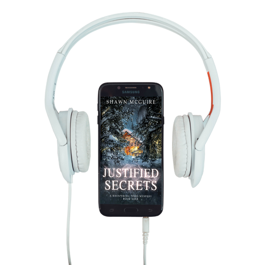Audiobook cover on cellphone of Shawn McGuire's cozy murder mystery featuring a cabin in the woods during a snowstorm.