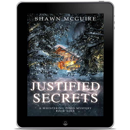 E-book cover on e-reader of Shawn McGuire's cozy murder mystery featuring a cabin in the woods during a snowstorm.
