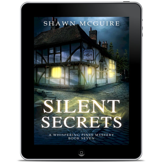 E-book cover on e-reader of Shawn McGuire's cozy murder mystery featuring a pub on a cobbled pathway.