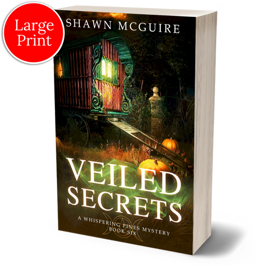 Large print paperback cover of Shawn McGuire's cozy murder mystery featuring a fortune teller’s wagon and Halloween pumpkins.