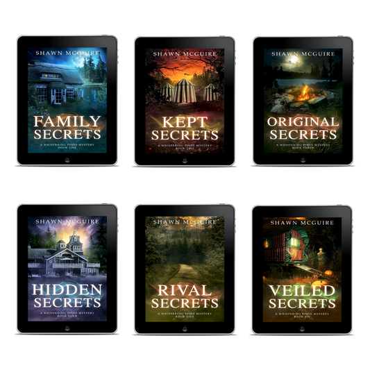 Six book covers of Whispering Pines mysteries series by Shawn McGuire on digital devices.