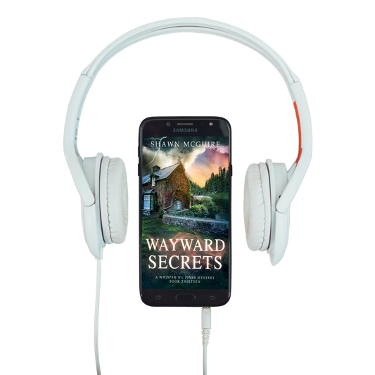 Audiobook cover on cellphone of Shawn McGuire's cozy murder mystery featuring a stone cottage on a lake beneath an ominous sky.